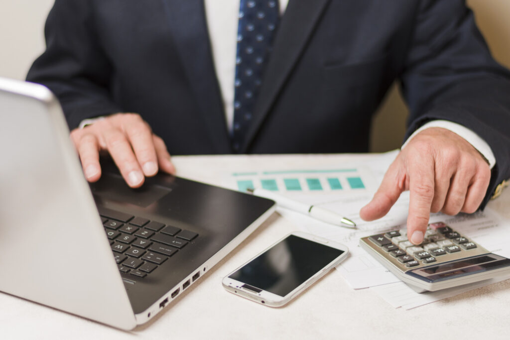 business man using a calculator - Revenue Tax Defaulters List search guide